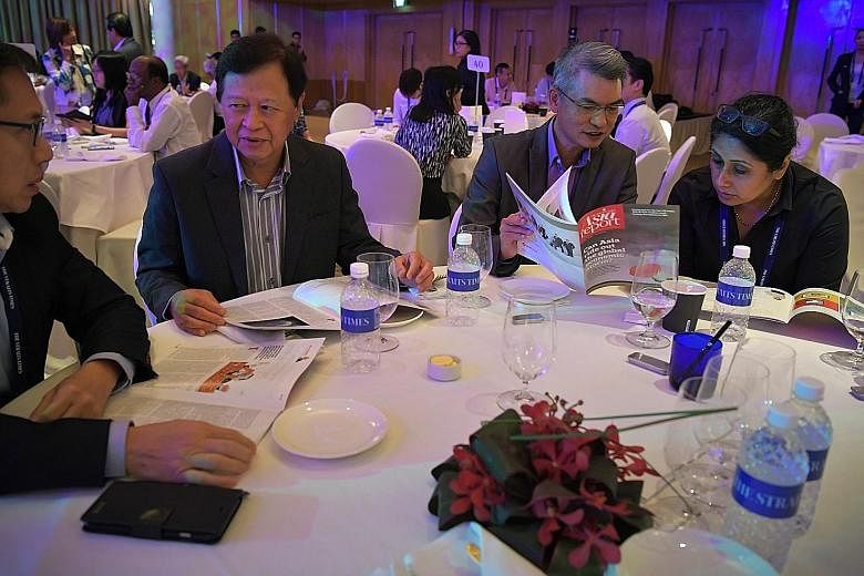 Participants at the ST Global Outlook Forum looking yesterday at the latest issue of the ST Asia report, a regular publication which compiles some of the best commentaries from its correspondents around the region. At the annual forum in the Ritz-Car