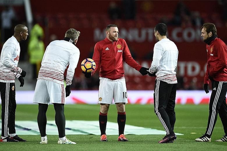 Manchester United captain Wayne Rooney (centre) talking with his team-mates ahead of their league game against West Ham. The teams meet again today with Rooney seeking a historic 249th United goal.