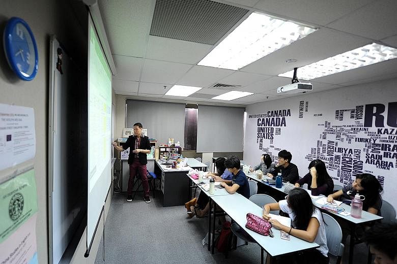 Humanities Hub tutor Chris Ho, 38, conducting an economics class. More students are seeking tuition in subjects that require critical analysis of sources and high-order thinking skills.