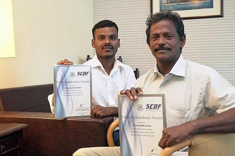Mr Rengasamy Kabilarasan (far left) and Mr Marudapillai Jayavelu climbed over the gates of a burning house to alert its residents and evacuated them to safety. They were presented with an award for bravery yesterday.