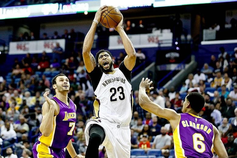 Pelicans' Anthony Davis drives between Lakers' Larry Nance Jr. and Jordan Clarkson at the Smoothie King Centre. Davis, the NBA's leading scorer, has finished with at least 35 points and 10 rebounds seven times this season.
