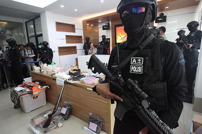 Indonesian anti-terror personnel standing guard over a display of evidence seized during a recent terror raid in Majalengka, West Java, during a press conference in Jakarta yesterday.