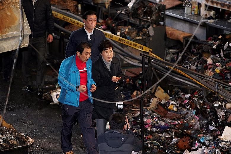 Ms Park visiting the Seomun market in her home town yesterday - her first public appearance in over three weeks. A fire had destroyed the sprawling century-old market in Daegu city on Wednesday.
