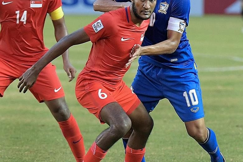 Lions defender Madhu Mohana shielding the ball from Thailand forward Teerasil Dangda during a Asean Football Federation Suzuki Cup match last Tuesday. Singapore lost the group game 1-0 and eventually failed to make the semi-finals while fellow four-t