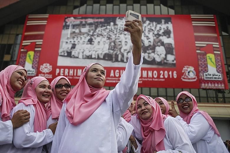 Party delegates taking a photo at the Umno general assembly in Kuala Lumpur yesterday. Mr Najib said yesterday that 10 bumiputera and Islamic bodies would be dismantled or weakened if the opposition takes power. But experts say most of these are form
