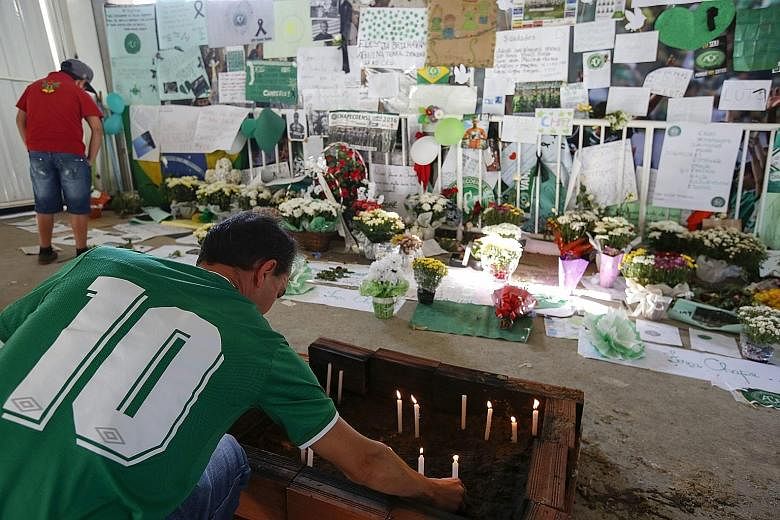 A supporter of the Brazilian club Chapecoense lighting candles during a vigil on Friday for the players and members of the technical team who died in a plane crash in Colombia on Monday.