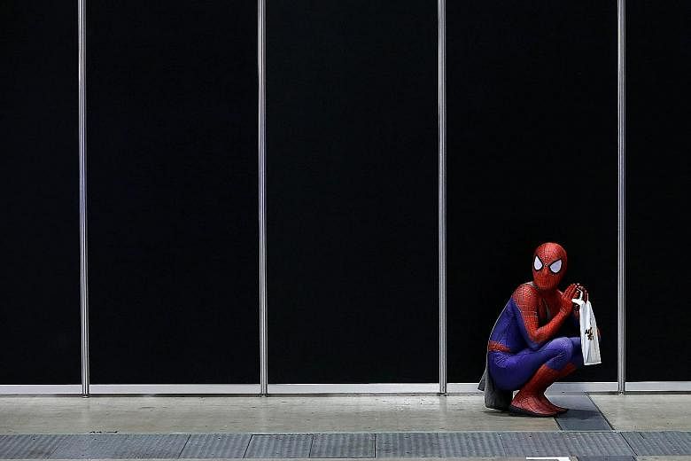 A man in a Spider-Man costume takes a rest at Tokyo Comic Con at the Makuhari Messe convention centre last Friday. The event, which ends today, celebrates all things pop culture with appearances by stars from hit movies, such as Jeremy Renner who pla