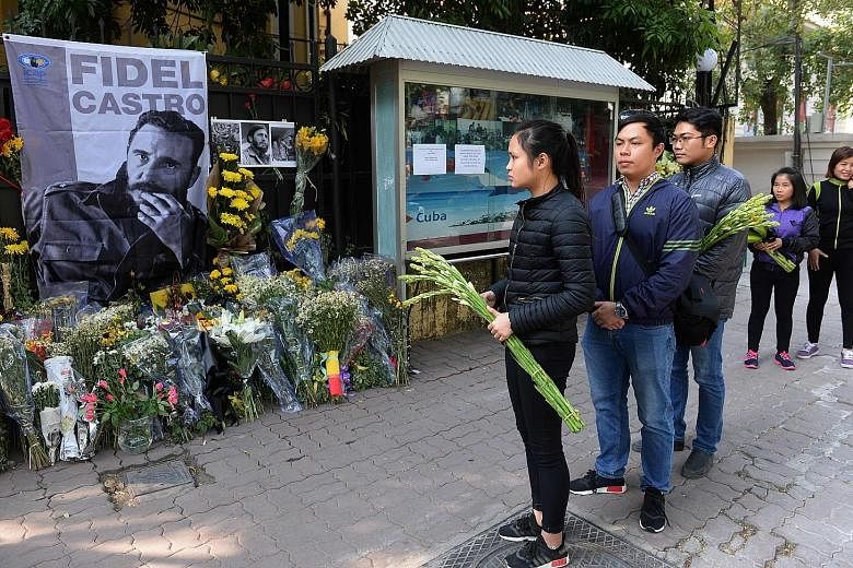 People in Hanoi, Vietnam, waiting to pay tribute to the late Fidel Castro at the Cuban embassy yesterday. The urn with the ashes of Cuban leader Fidel Castro leaving Revolution Square yesterday, on its way to the cemetery in the eastern city of Santi