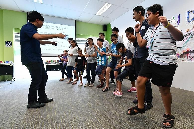 Conductor Wong Kah Chun leading the children in a body percussion session at The Enabling Village in Lengkok Bahru.