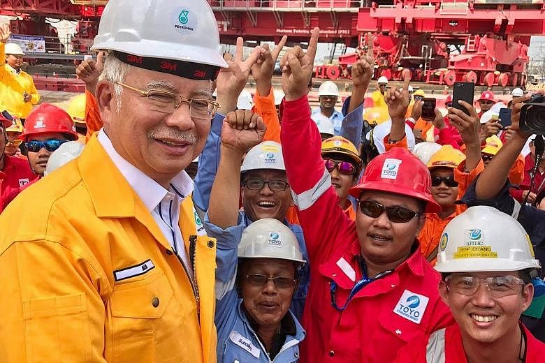 PM Najib with workers at the Pengerang Integrated Complex in Johor yesterday.