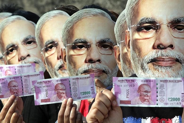 Demonstrators, wearing masks of Indian PM Narendra Modi, holding new currency notes in support of his move to ban 500- and 1,000-rupee notes, in Jammu, Kashmir, last month. The rise of underground networks illustrates the challenge he faces in trying