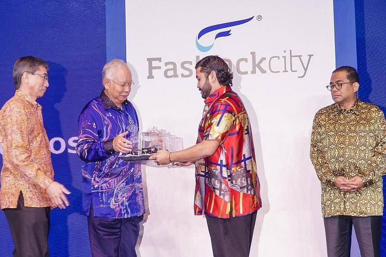 Above: The centrepiece of Fastrackcity, a 10-minute drive from the Tuas Second Link, is the 15-turn 4.45km track which is certified to stage Formula One races. Left: Johor Crown Prince Tunku Ismail Sultan Ibrahim giving a model of a racing car to Mal