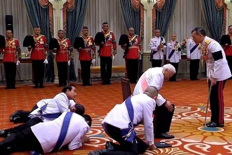 A screen grab from Thai TV on Dec 1 showed privy council president Prem Tinsulanonda (with pink sash) bowing and Prime Minister Prayut Chan-o-cha prostrating as he looked up to King Maha Vajiralongkorn.
