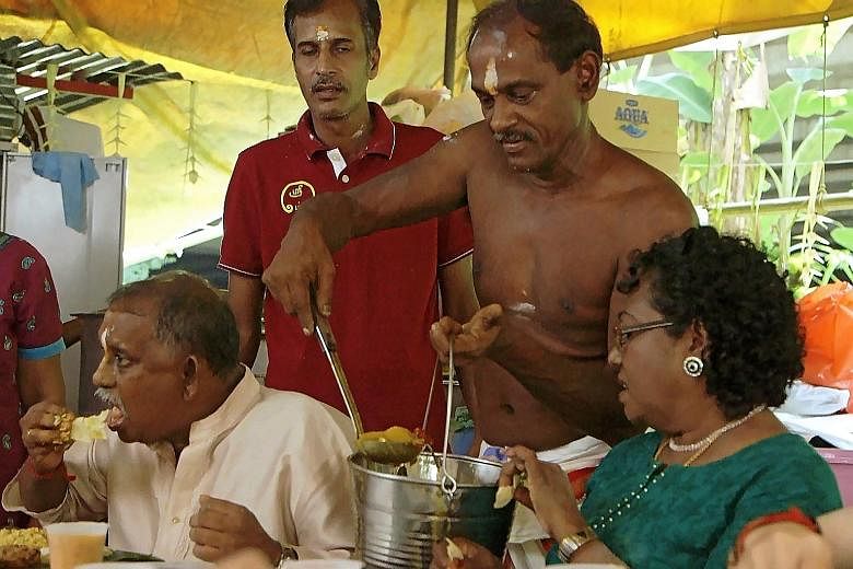 Mr Adaikalam Annadhurai (second from right) serving lunch to devotees after morning prayers on a Saturday at the Sri Thandavaalam Muneeswaran Alayam Shrine, a little-known Hindu shrine in Queensway.