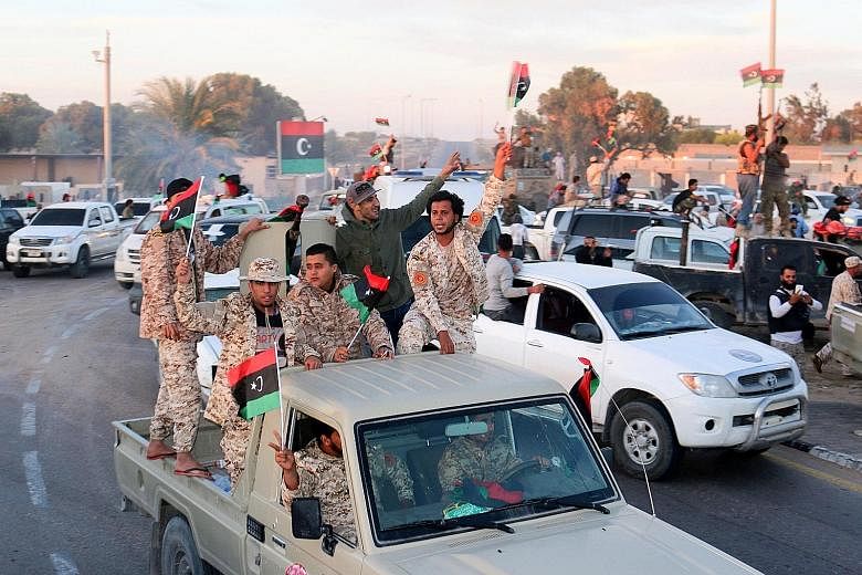 Libyan fighters celebrating after taking ISIS' coastal stronghold.