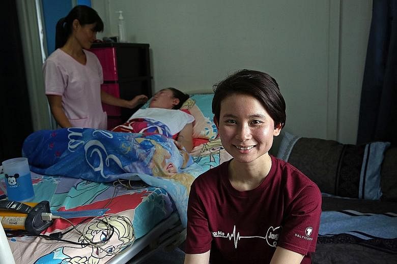 Jaga-Me co-founder Kuah Ling Ling (foreground), 30, in the home of patient Bella Tan, who is being attended to by HCA Hospice Care nurse Serene Wong, 41. Jaga-Me helped HCA provide a nurse on short notice to relieve Bella's mother when she could not 