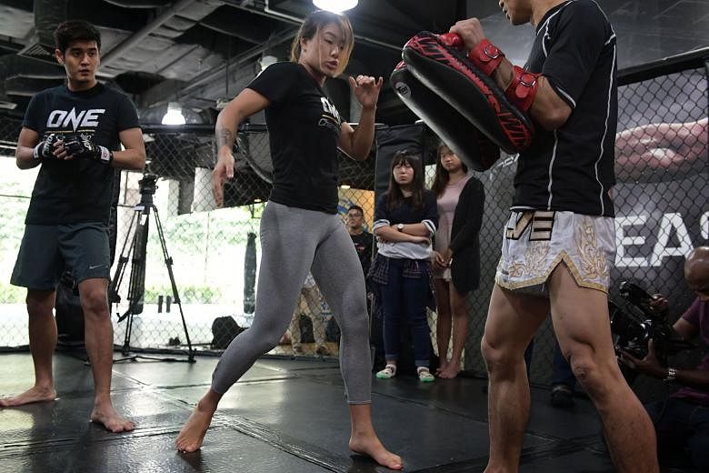 Angela Lee, the One Championship women's atomweight world champion, during a workshop she conducted for Singaporean pop star Nathan Hartono yesterday. The 20-year-old has been training with former Ultimate Fighting Championship bantamweight champion Miesh