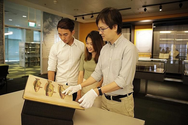 From left: Undergraduates Clarence Sim and Shaina Tan with Mr Ong Eng Chuan, senior librarian of the NLB's Exhibitions, Curation and Rare Collection. The NLB is the first South-east Asian partner to join a Smithsonian initiative which aims to provide