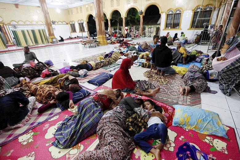 Survivors spending the night at an evacuation centre in Meureudu, in Pidie Jaya regency, after the earthquake struck Aceh province on Wednesday. More than 11,100 people have been displaced from their homes over fears that houses may collapse from the