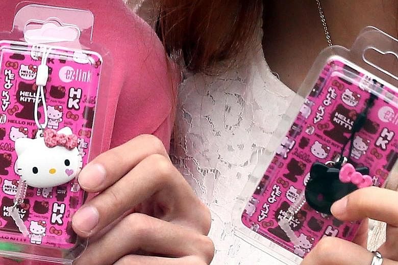 It was a Hello Kitty craze of a different kind yesterday as nearly 10,000 people turned up at 14 7-Eleven outlets islandwide to queue for ez-link charms (left) bearing the famous kitty's likeness. Among the queues was this one at an outlet next to th