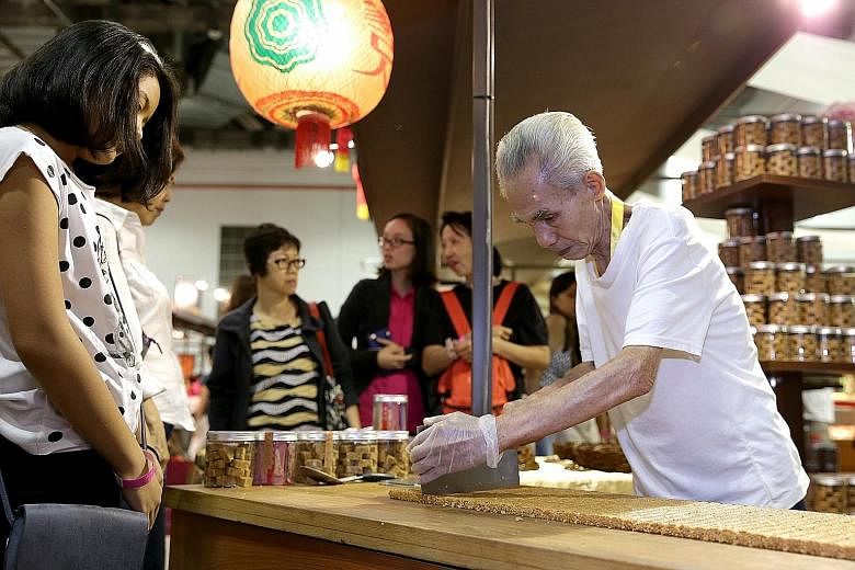Above: Veteran Thye Moh Chan pastry chef Chua Cha Lai, 77, demonstrates the process of making peanut candy, a traditional Teochew snack that is eaten during weddings and festive occasions. Below:Members of the Xiao Mei Hua Opera Troupe preparing back