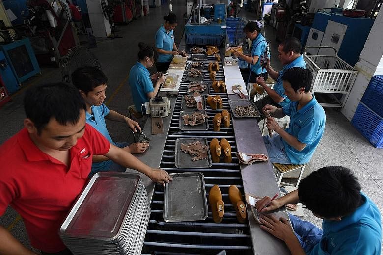 Workers at a shoe factory in Dongguan, in Guangdong province, on Sept 14. The Chinese economy has surpassed market expectations to grow by 6.7 per cent for three consecutive quarters this year.