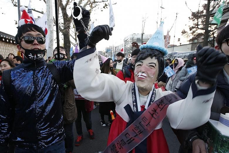 A protester wearing a mask of South Korean President Park Geun Hye taking part in a rally in Seoul's Gwanghwamun Square, as the crowd marched towards the presidential Blue House yesterday.