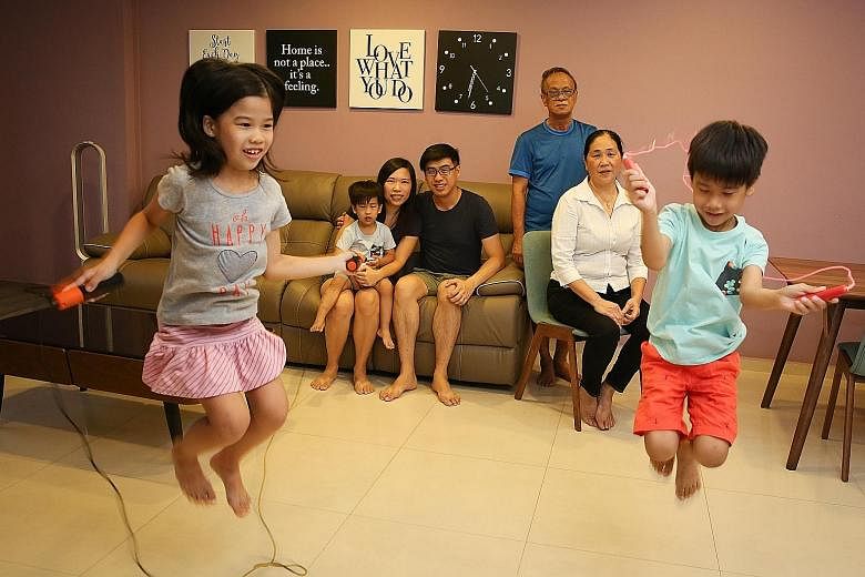 Madam Aw Young and Mr Wang (both seated on sofa) now live near Mr Wang's parents, Mr Wong Chin Poke, 65, and Madam Ng Sai Keaw, 58. The younger couple say the grant money will be saved for the education of their children, (from left) Felicia, eight, 