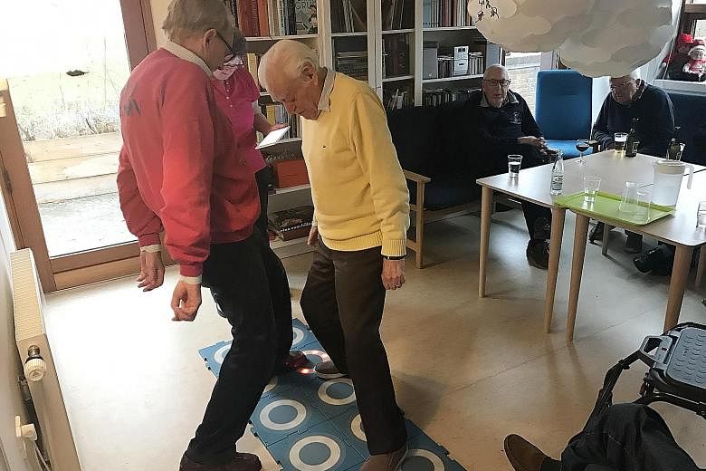 This rehabilitative game makes use of interactive tiles to help seniors (from left) Hans Joergen and Bendt Fogh improve their balance and reflexes while having a fun workout at the Vennerslund Day Centre.