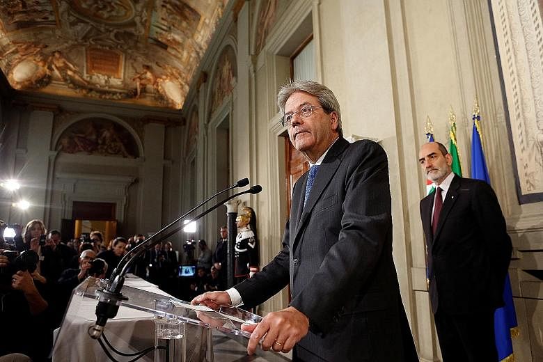 Mr Gentiloni (at podium) is to begin consultations to form a government. If he fails, President Mattarella could ask someone else to try. If he succeeds, a new government could be installed within days.