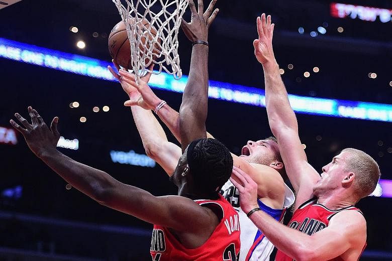 Clippers star Blake Griffin scores between Noah Vonleh and Mason Plumlee of the Trail Blazers. Griffin was the leading scorer in the Clippers' 121-120 win with 26 points.