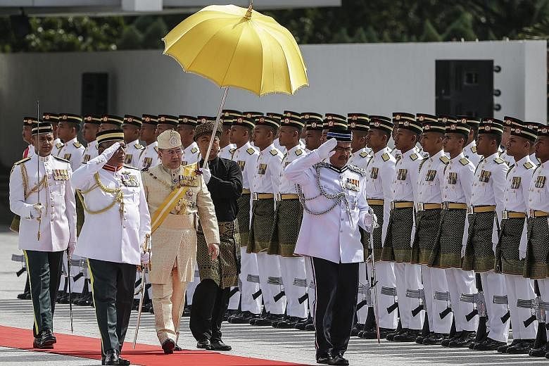 Sultan Muhammad V, dressed in gold-coloured traditional Malay formal wear, inspecting a guard of honour during the official welcoming ceremony at Parliament Square in Kuala Lumpur yesterday. The relatively youthful monarch is known for his relaxed pu