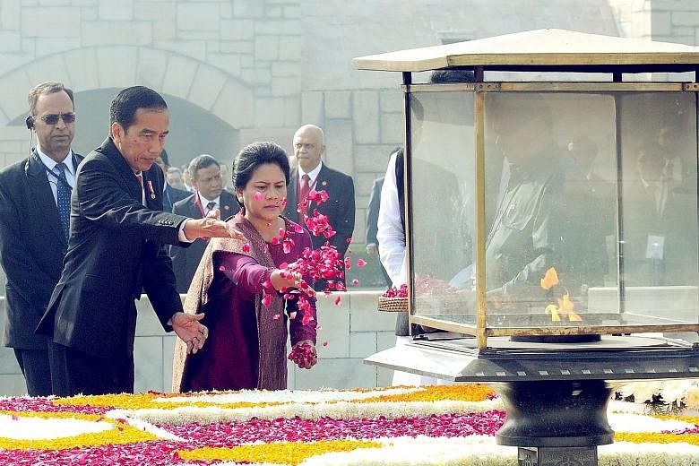 President Joko and his wife pay their respects with floral tributes at The Samadhi or cremation site of Mahatma Gandhi at Raj Ghat in New Delhi.