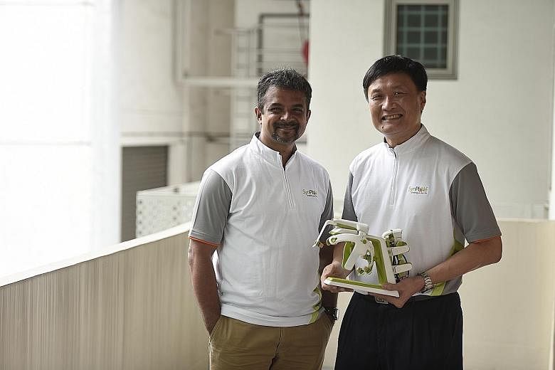 Dr Banerji and Dr Heng with the SynPhNe device, which stands for "synergy between physio and neuro". The specially designed headset comes with neural sensors and an arm glove with muscle activity sensors.