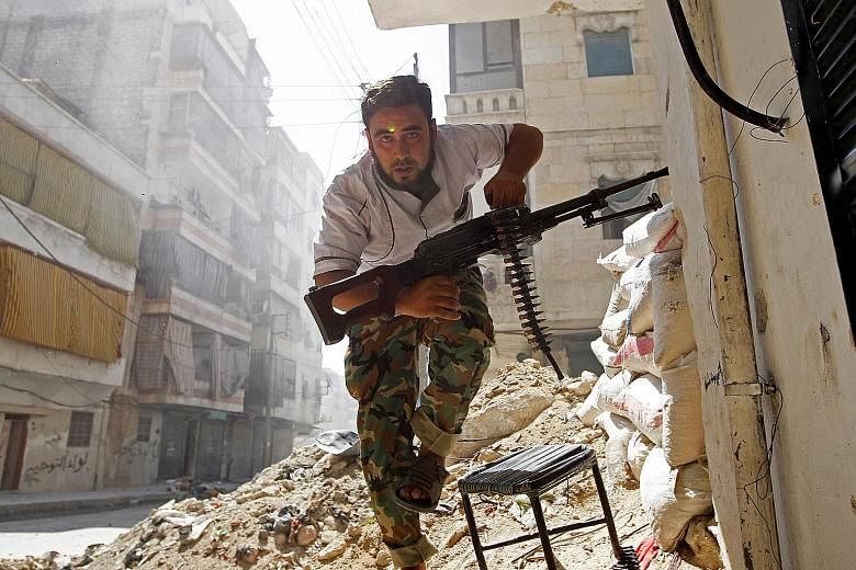 A Free Syrian Army fighter taking cover during clashes with the Syrian Army in central Aleppo in August 2012.