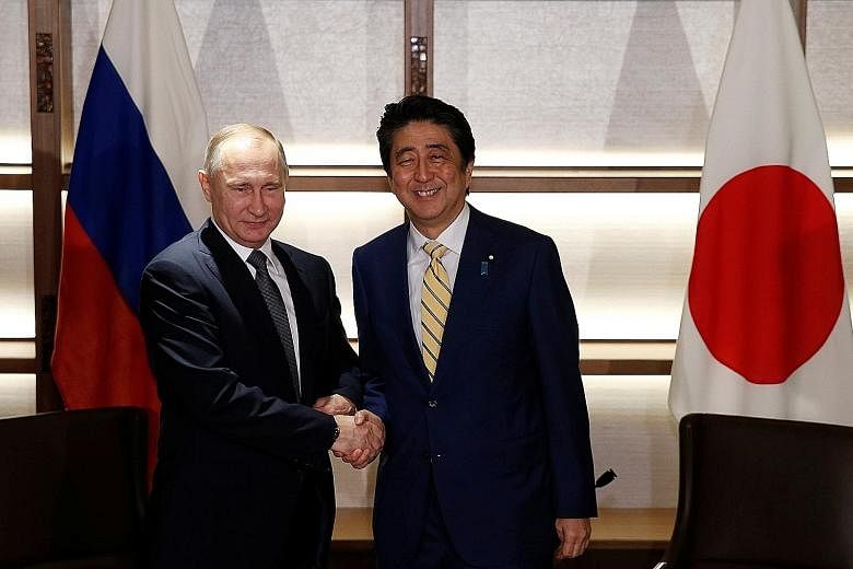 President Putin with Prime Minister Abe at the start of their summit in Nagato, Yamaguchi, yesterday. They ordered a start to talks on conditions for joint economic activity on the four islands.