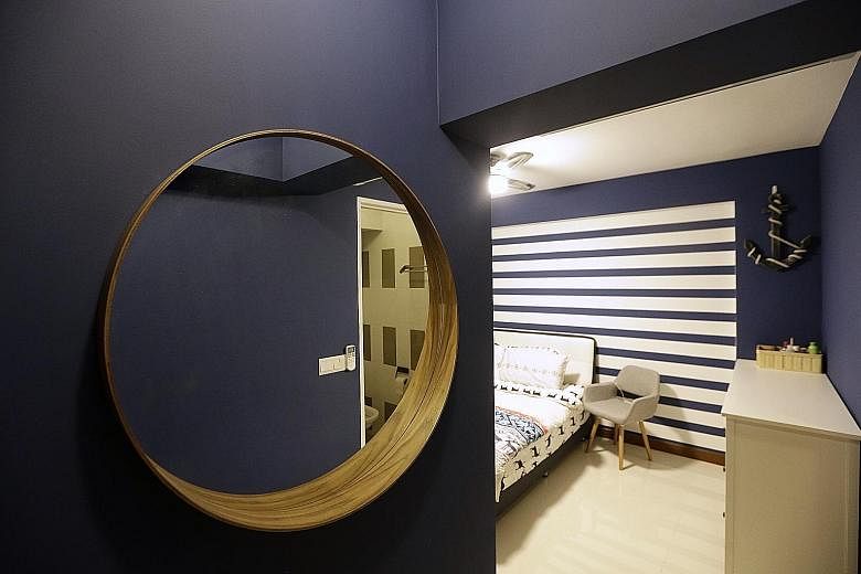 A porthole-inspired mirror and a blue-and-white striped feature wall (above) are part of the nautical-themed bedroom. A chalkboard panel (above) outside the kitchen is used for doodling. Recycled pallet wood and black piping are used to create the te