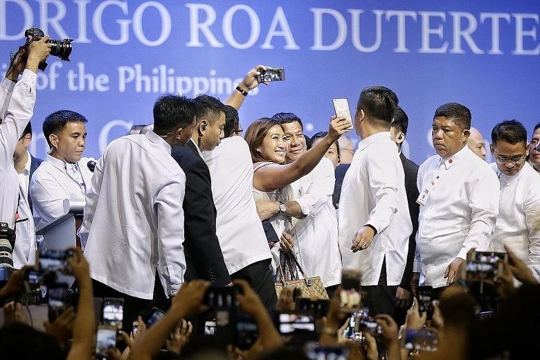 Mr Duterte posing for a wefie with a member of the audience after addressing the Filipino community at the Singapore Expo yesterday. Nearly 7,000 people turned up for the event.