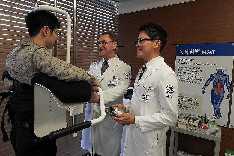 Dr Choi Woo Jung (left) says the Kwangdong Hospital of Traditional Korean Medicine draws 1,500 foreign patients a year. Korean traditional medicine includes the use of acupuncture which figure skater Kim Yuna (above, left) used to treat her back pain