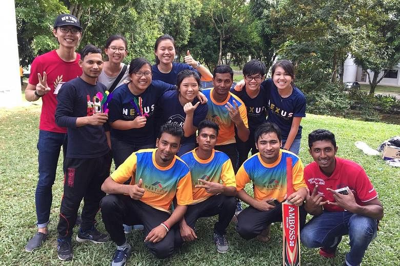 Students from the NUS College of Alice and Peter Tan with migrant workers from India and Bangladesh after a cricket match on Dec 4. The workers, who enjoyed a rousing game and a carefree day out in the sun, also got their blood pressure measured.