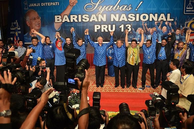 PM Najib Razak and his fellow Barisan Nasional party members celebrating their win at the 2013 general election. While speculations are rife, he has until August 2018 to call for the coming polls.