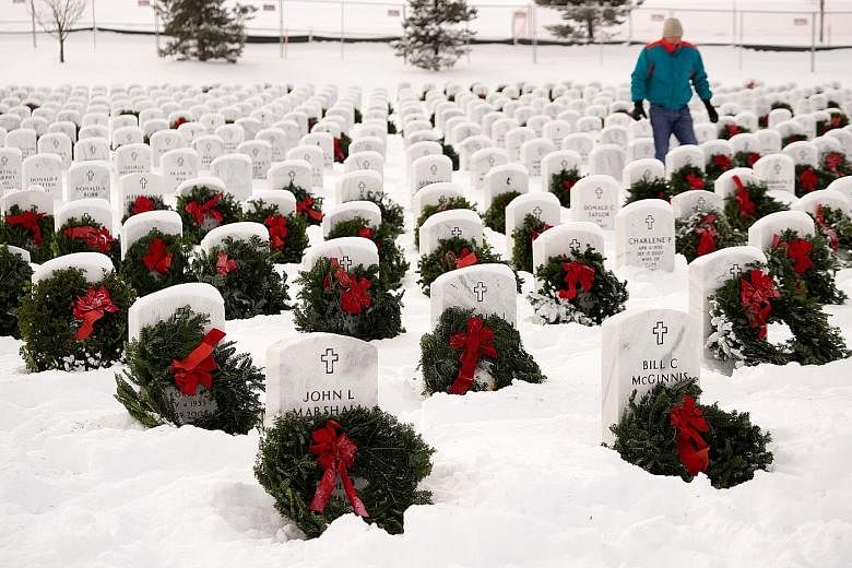 Christmas wreaths decorating military graves at the Fort Logan National Cemetery in Denver, Colorado, as part of the Wreaths Across America initiative on Saturday. Each December, volunteers aim to lay wreaths on graves of war veterans at more than 1,
