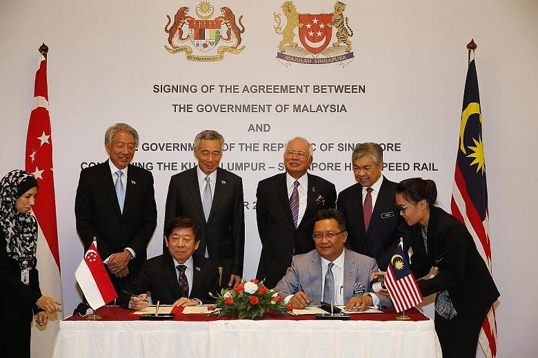 Mr Rahman (seated, left) and Transport Minister Khaw Boon Wan (seated, far left) signing the High-Speed Rail agreement last week. With them are (standing, from far left) DPM Teo Chee Hean, PM Lee Hsien Loong, Malaysian PM Najib Razak and Malaysian DP