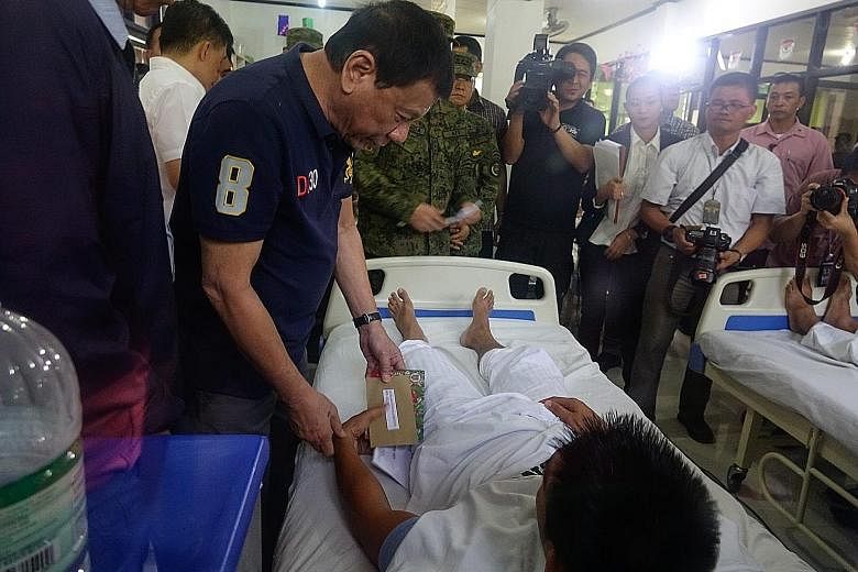 Mr Duterte, seen here with a wounded soldier, has admitted to taking fentanyl due to a spinal injury from previous motorcycle accidents.