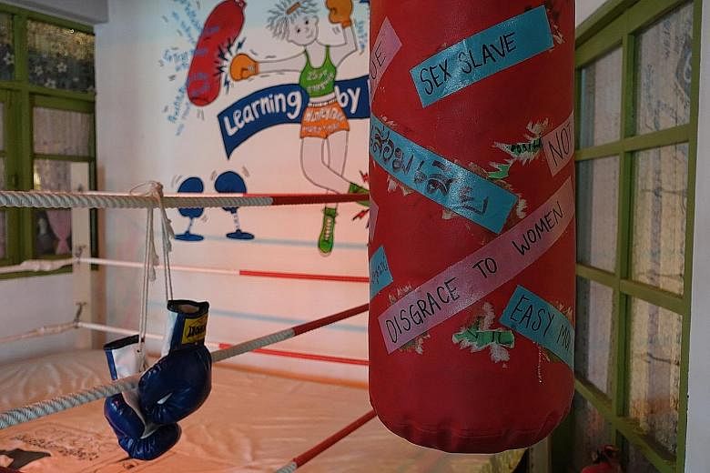 A punching bag with phrases used to describe sex workers at Empower Foundation's This Is Us museum in Nonthaburi province, just outside Bangkok. Visitors are invited to put on the boxing gloves and have a go at demolishing such prejudices.
