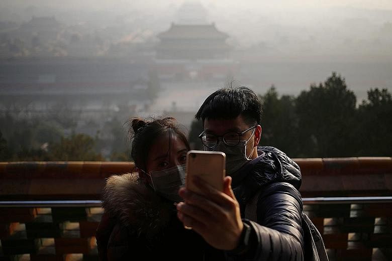 The scene in Liaocheng, Shandong province, yesterday. At least 23 cities in China have issued red alerts on air pollution since Friday. The Forbidden City in Beijing yesterday. PM2.5 levels were around 200, according to data by the US Embassy. A road