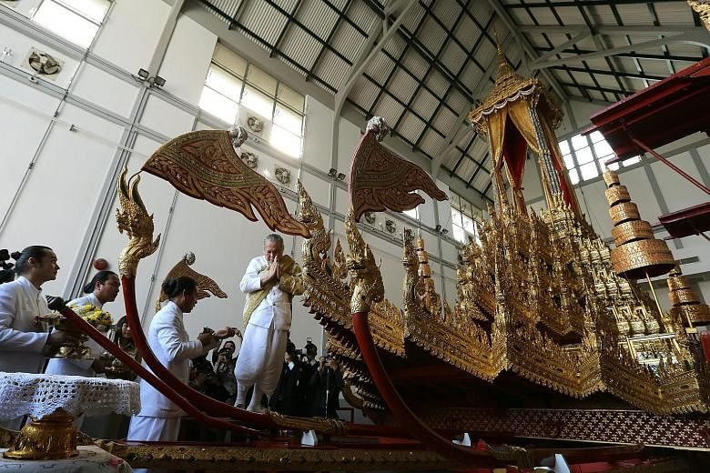 Thai royal officials dressed in Brahman costumes marking the sacrificial ceremony for the restoration of the Royal Chariots at the National Museum in Bangkok yesterday. The chariots will be used to carry the body and royal urn of Thai King Bhumibol A