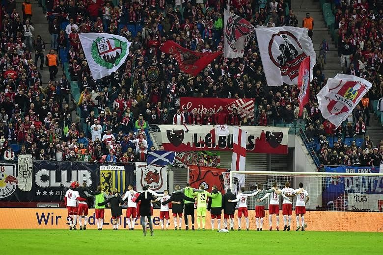 RB Leipzig players celebrating with their fans after beating Mainz in the Bundesliga last month. Their next league match will be a top-of-the-table clash against mighty Bayern Munich tonight.