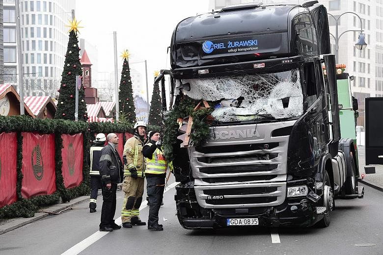 (Anti-clockwise from top): Policemen standing guard near the truck in Berlin on Monday night after it crashed into a Christmas market, killing 12 people; the truck being examined yesterday; and a woman praying yesterday near the scene of the attack, 