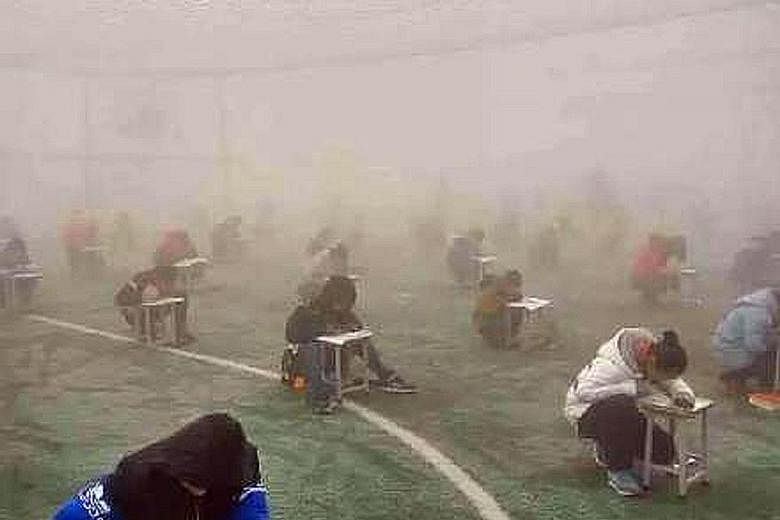 A school in central Henan province has come under fire for making students take their exams in an open field on Monday.